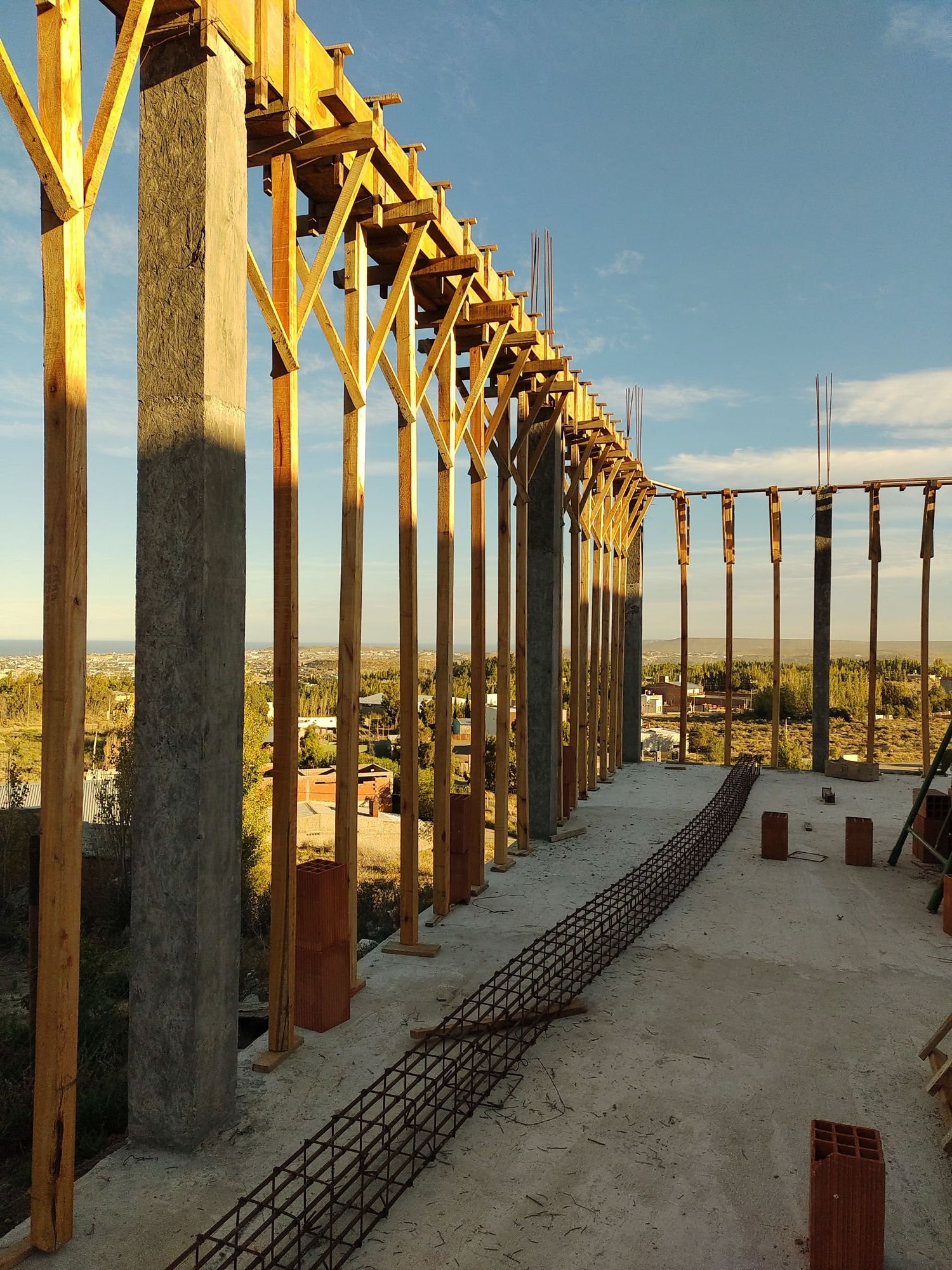 Estructura de hormigón y encofrado de madera de un desarrollo en ejecución, con vista al valle