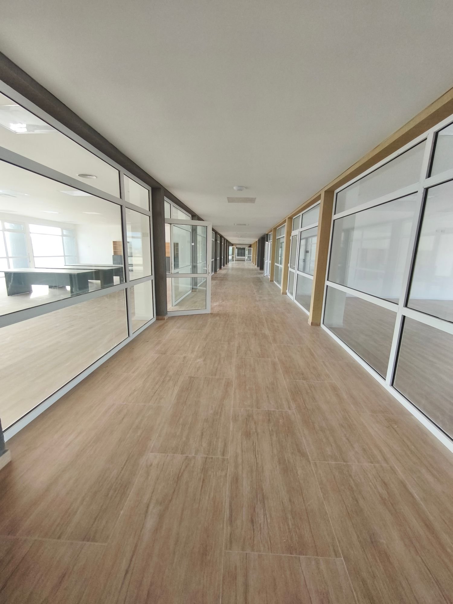 Circulación de un edificio comercial terminado, con oficinas vidriadas a ambos lados