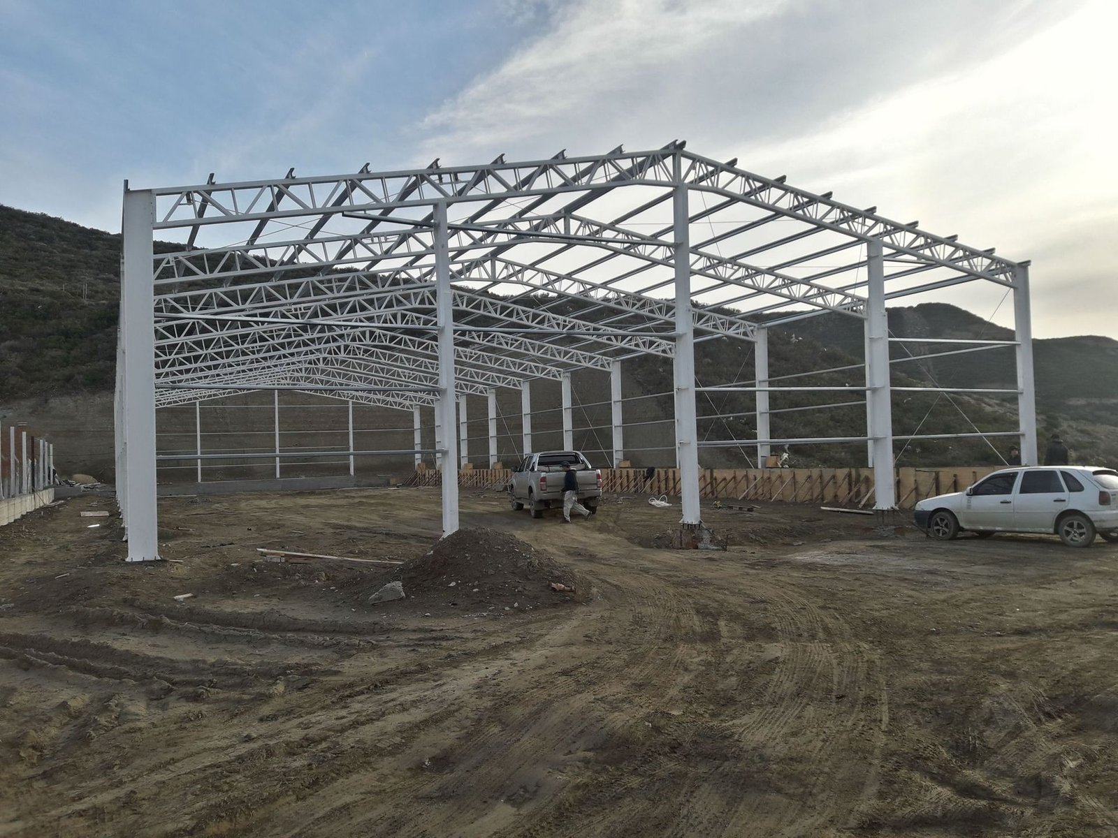 Estructura metálica de una nave industrial montada en un terreno de meseta